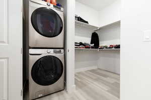 Owners Suite featuring private stacked washer  and dryerin the center of two large walk-in closets.