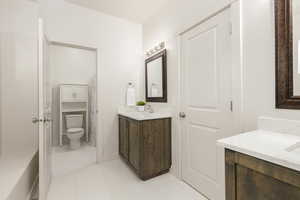 Jack & Jill bathroom featuring two vanities and light tile  flooring