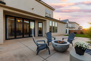 Patio terrace at dusk featuring an outdoor fire pit
