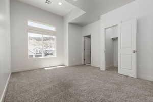 Bedroom featuring light colored carpet, a walk in closet, and recessed lighting. Sharing Jack & Jill bathroom.