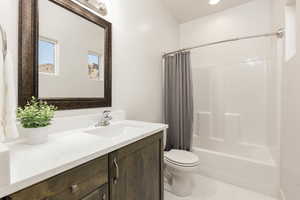 Bathroom featuring shower / bath combination, vanity, light tile floors, vanity lighting and decorative windows for natural lighting