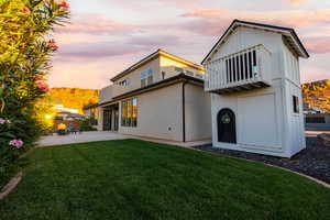 Rear view of house with a yard, two story playhouse and a mountain view