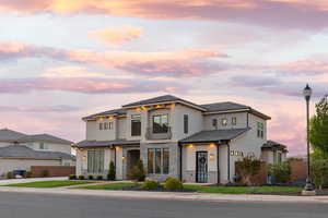 View of front of house featuring stone siding, stucco siding, a balcony, and a tiled roof