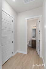 Hallway with light wood-style floors and baseboards