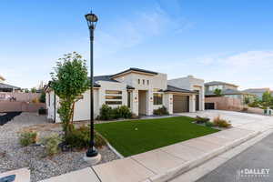 View of front of home with concrete driveway, stucco siding, a garage, and stone siding
