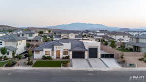 View of front of property featuring a residential view, stucco siding, driveway, and a garage