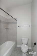 Bathroom with tile patterned floors and washtub / shower combination