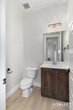 Half bathroom with vanity and light wood-style floors