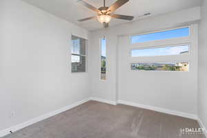 Carpeted bedroom featuring baseboards and a ceiling fan