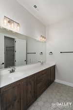 Bathroom with double vanity and light tile patterned floors