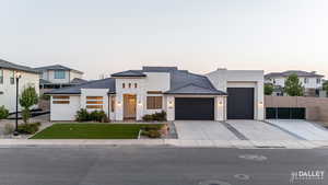 Contemporary home with stone siding, stucco siding, an attached garage, and concrete driveway