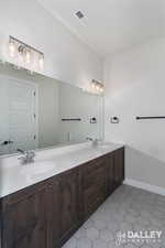 Bathroom with double vanity and light tile patterned flooring