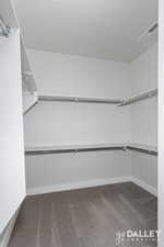 Walk in closet featuring dark carpet