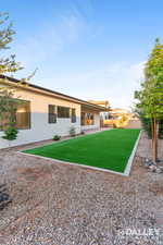 Back of house featuring stucco siding and new turf