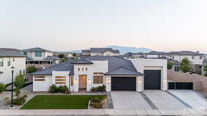 View of front of house with stone siding, stucco siding, an attached garage, a residential view, and concrete driveway