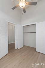 Bedroom/Front Office featuring light wood finished floors, a closet, ceiling fan, and a high ceiling