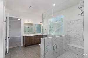 Full bath featuring vanity, a marble finish shower, light tile patterned floors, and recessed lighting