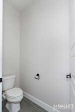 Bathroom with dark tile patterned floors and toilet