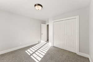 Unfurnished bedroom featuring a closet and light carpet