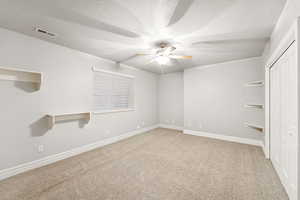 Unfurnished bedroom with a closet, light carpet, a textured ceiling, and a ceiling fan
