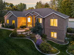 View of front facade featuring brick siding and a lawn