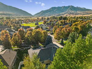 Aerial view of property and surrounding area with mountains and nearby suburban area