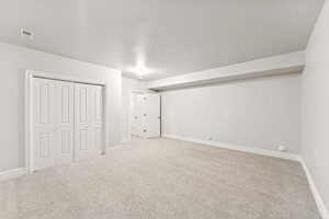 Below grade area with carpet and a textured ceiling