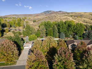 Aerial view of property's location with mountains and a tree filled landscape