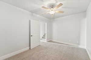 Unfurnished room featuring light colored carpet and ceiling fan