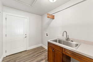 Washroom with washer hookup, dark wood finished floors, and cabinet space