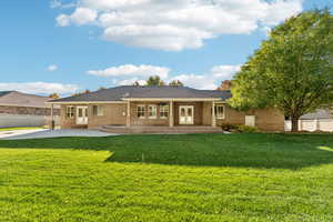 Rear view of house with a patio area, brick siding, and french doors