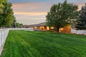 Yard at dusk featuring a fenced backyard and a patio area