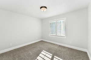 Spare room featuring carpet floors and baseboards