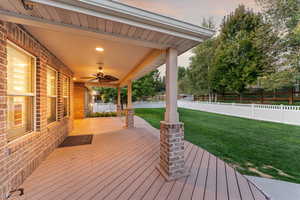 Wooden terrace with a fenced backyard and ceiling fan