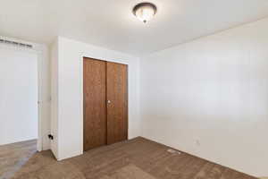 Unfurnished bedroom with carpet flooring and a closet