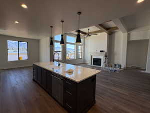 Kitchen with recessed lighting, open floor plan, a fireplace, pendant lighting, and a ceiling fan