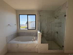 Full bathroom featuring a marble finish shower and a bath