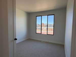 Spare room featuring baseboards and carpet