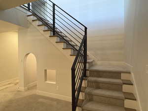 Stairs featuring baseboards and carpet