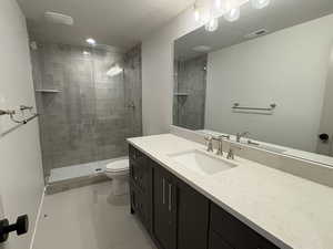Bathroom with vanity, a shower stall, light tile patterned floors, and a textured ceiling