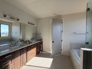 Full bathroom with a garden tub, double vanity, and a shower stall