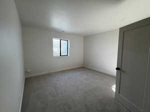 Spare room featuring light carpet and baseboards