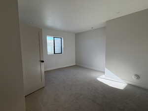 Spare room with light colored carpet and baseboards