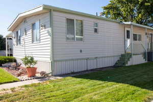 View of side of home with a yard