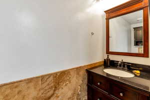 Bathroom featuring a wainscoted wall and vanity