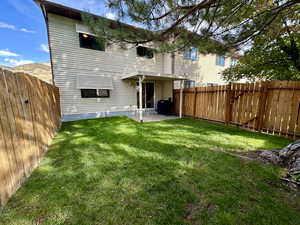 Back of property with a fenced backyard and a patio area