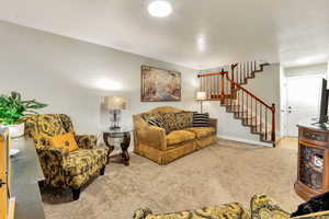 Living room featuring carpet flooring and stairs
