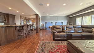 Living area with dark wood-type flooring, recessed lighting, and a textured ceiling