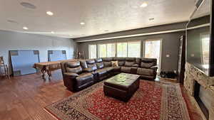 Living room featuring recessed lighting, dark wood-style flooring, a textured ceiling, and pool table