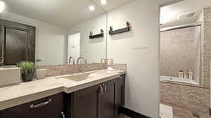 Bathroom with vanity, decorative backsplash, and recessed lighting